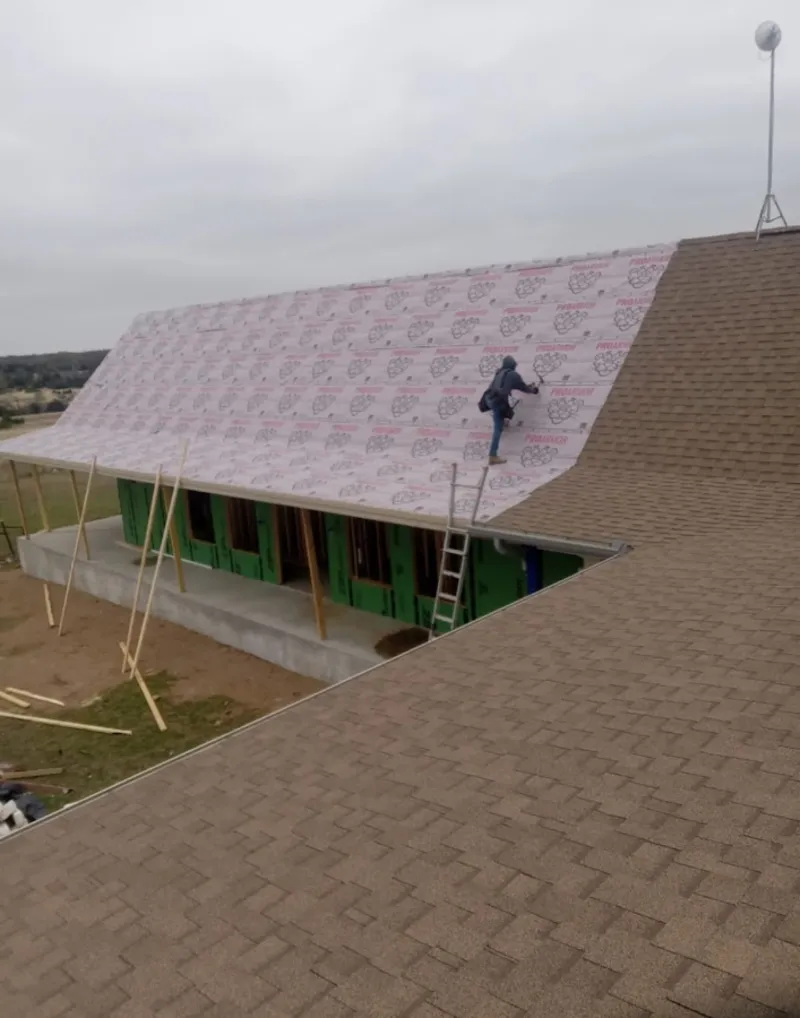 Worker preparing underlayment for a metal roof installation in Santa Clara